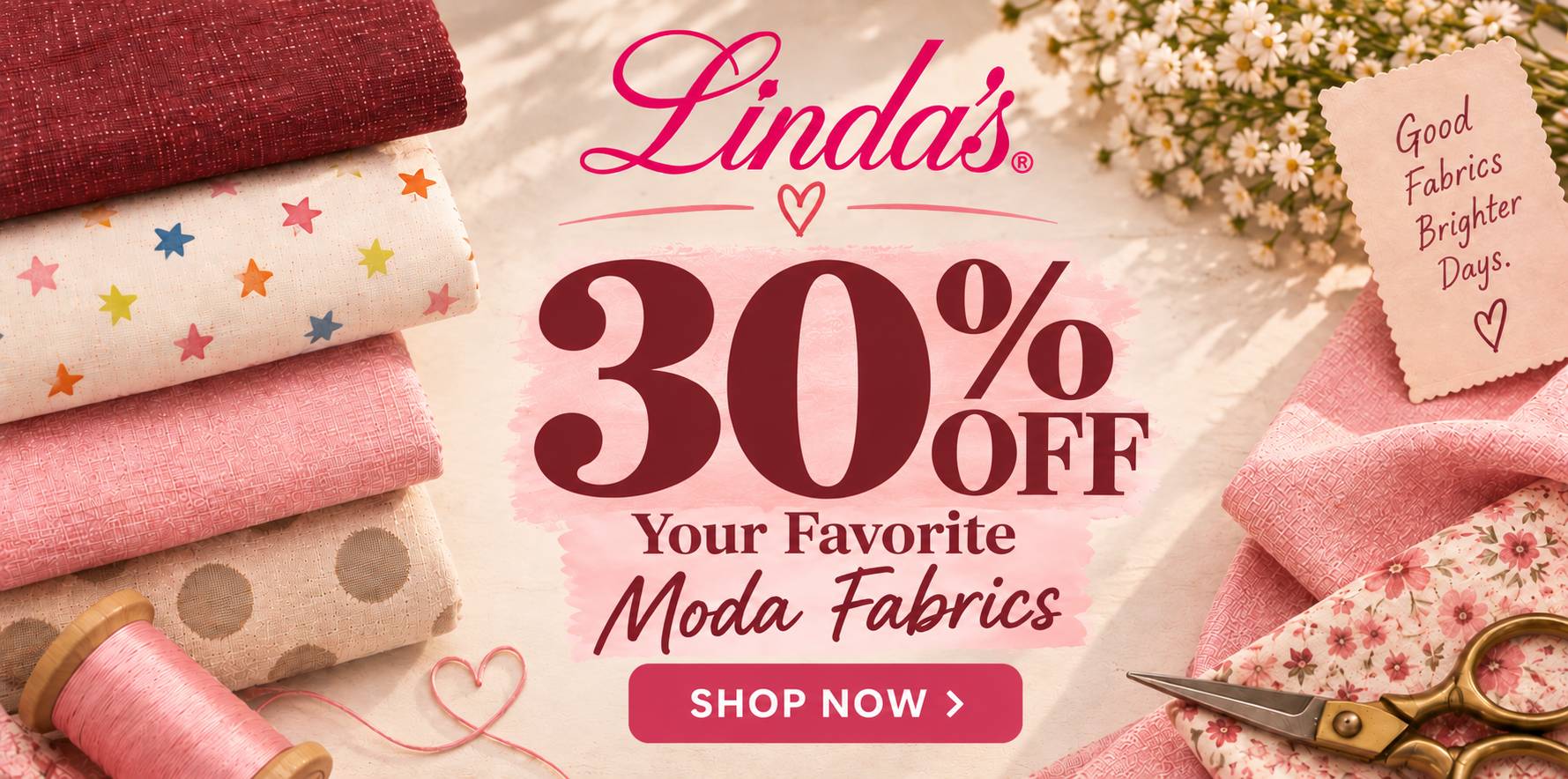 A wide, overhead-style fabric promotion shows folded red, cream, pink, and beige patterned fabrics, a pink thread spool, scissors, daisies, and a scal...
