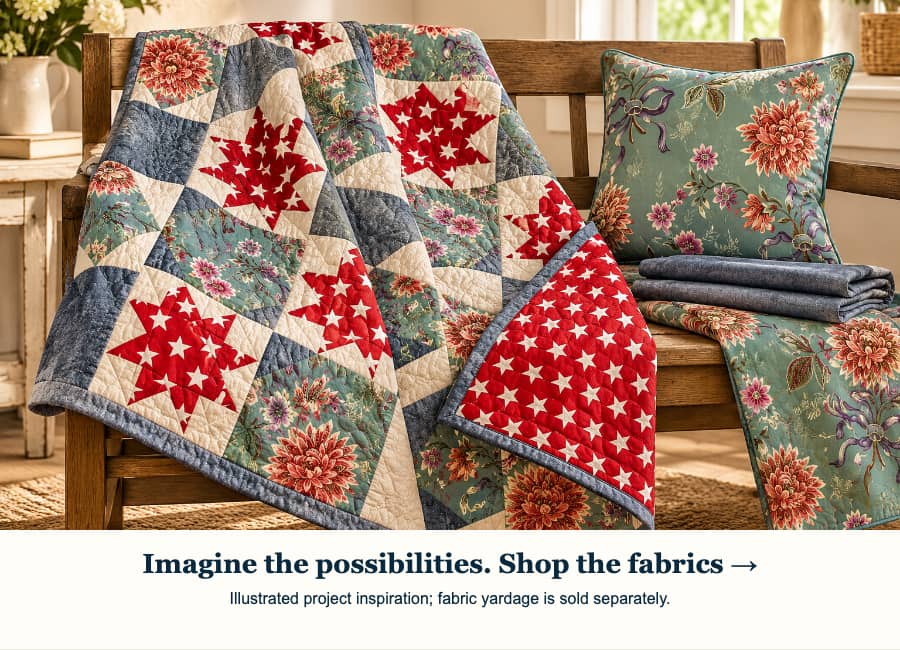 A wide, warmly lit indoor scene shows a red, cream, blue-gray, and muted teal patchwork quilt with star and floral blocks draped over a wooden bench, ...